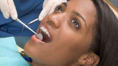 woman getting checked for root canal treatment at the dentist in Troy NY