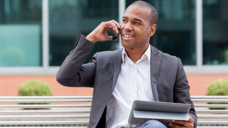 man sitting while talking to his phone