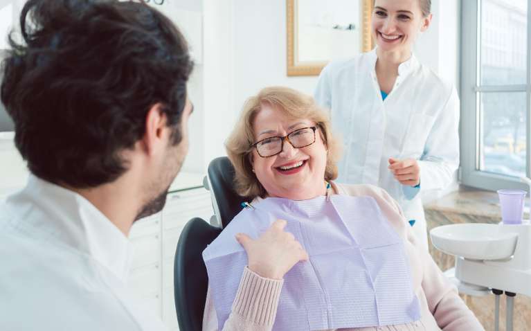 Female patient happily smiling with her dentists | Deep cleaning in Troy NY
