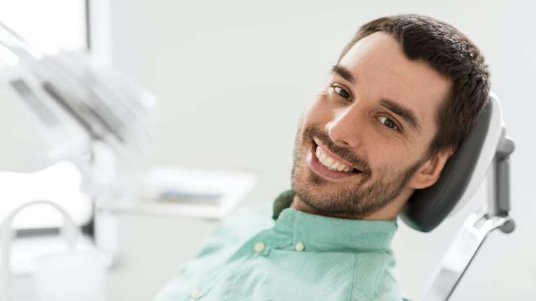 man smiling at the dental office near me in Troy