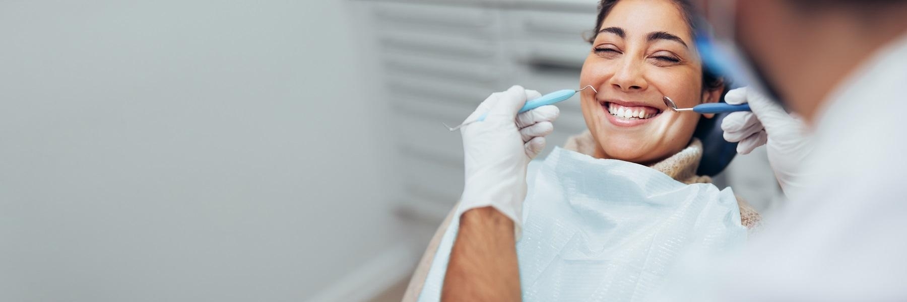 woman smiling during dental exam in Troy