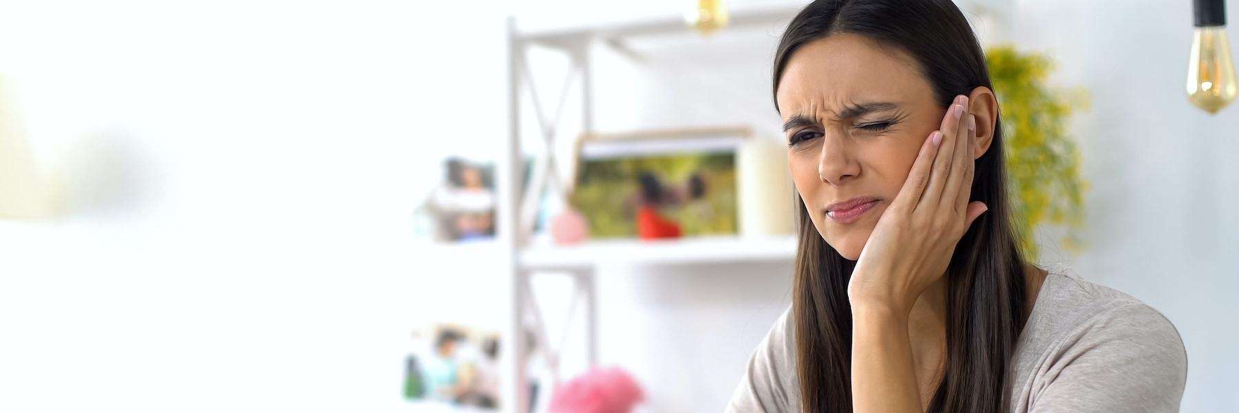 woman in pain holding jaw during tooth emergency
