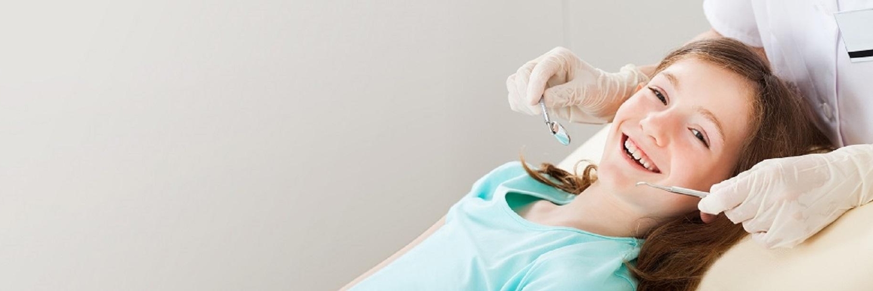 young girl smiling in dental chair during checkup 