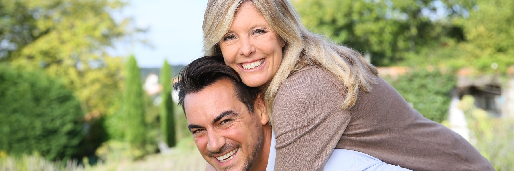 woman hugging husband's shoulders from behind